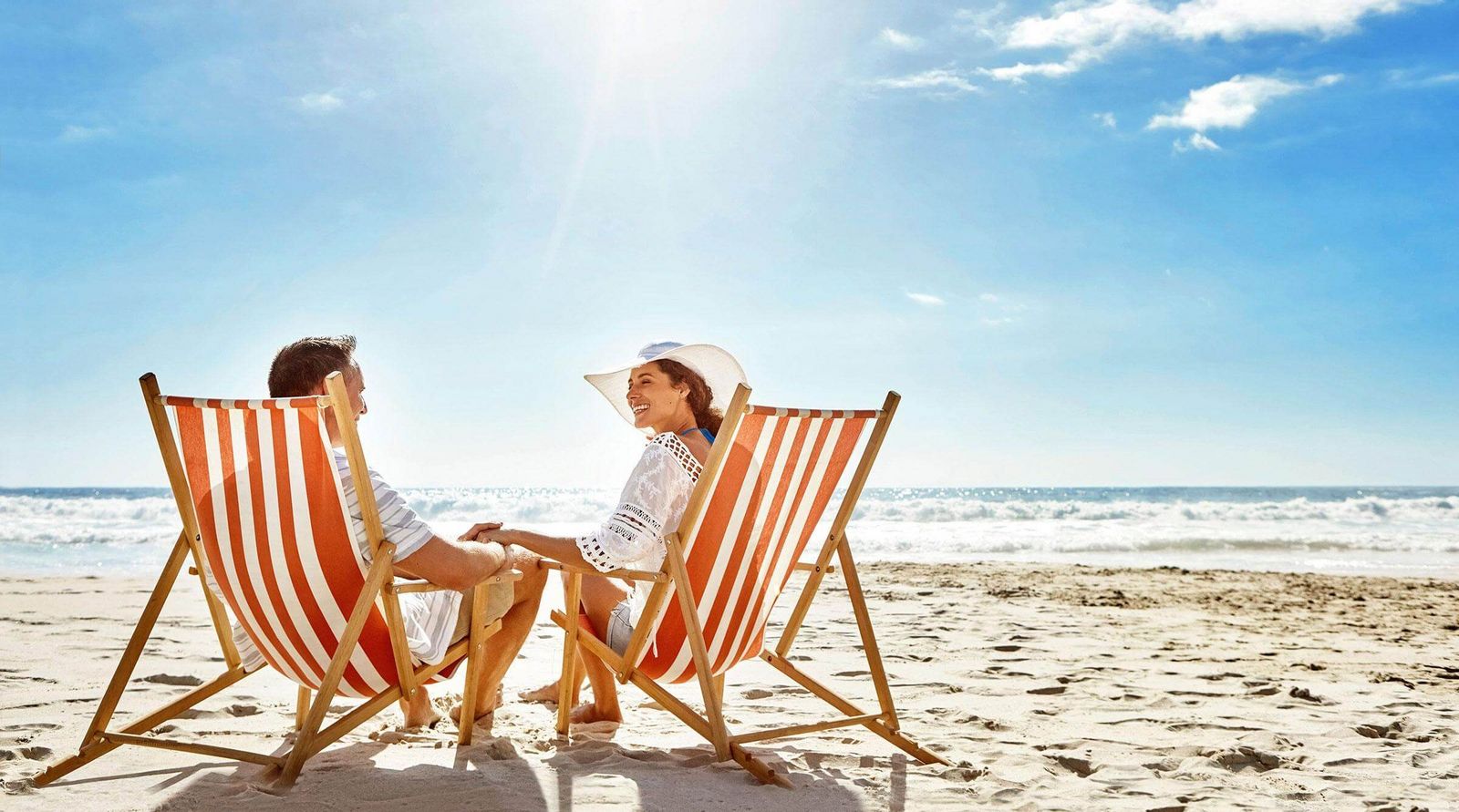 Ein Paar in gestreiften Liegestühlen am Strand