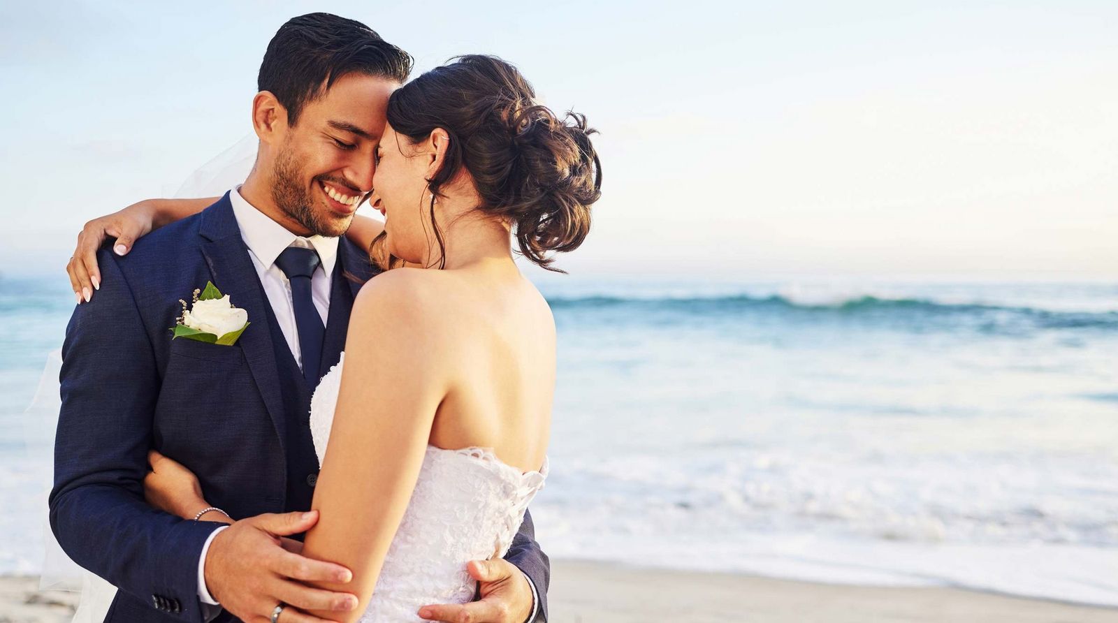 Flitterwochen ein frisch vermaehltes Ehepaar haelt sich am Strand in den Armen