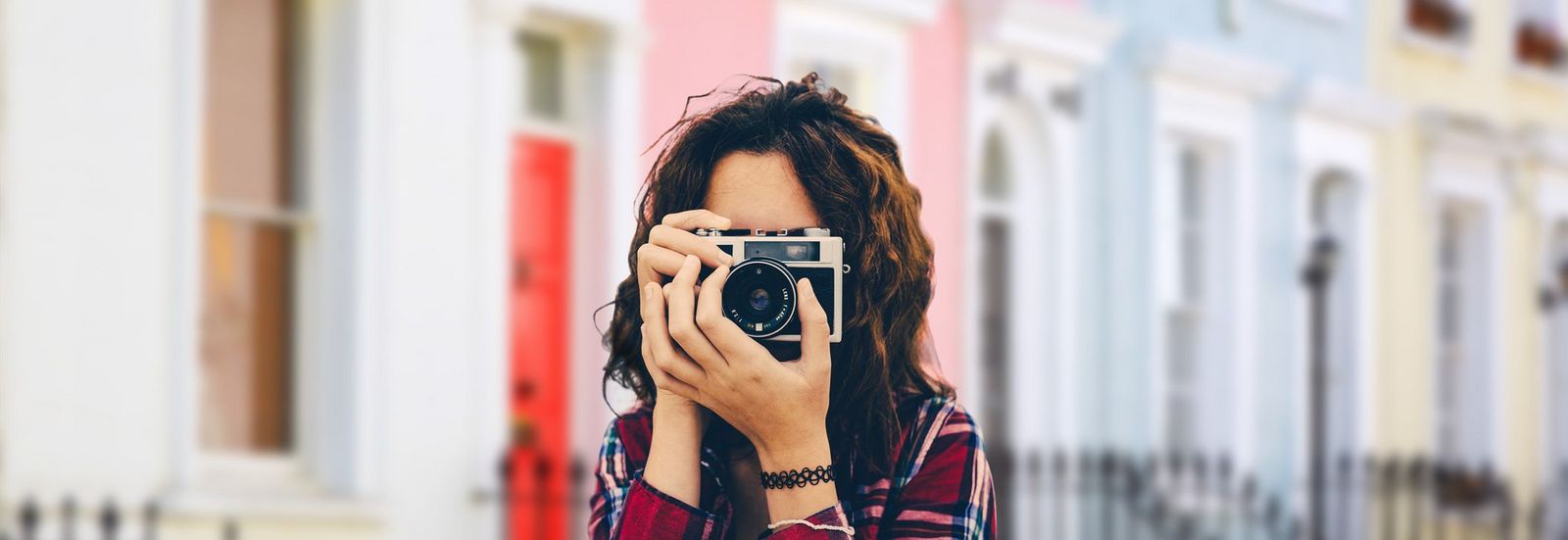 Reiseblog Frau mit Kamera vor bunten Haeusern