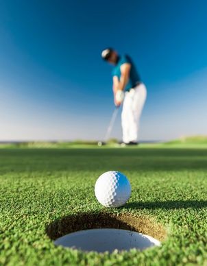 Ein Mann in weisser Hose beim Golfen auf dem Golfplatz