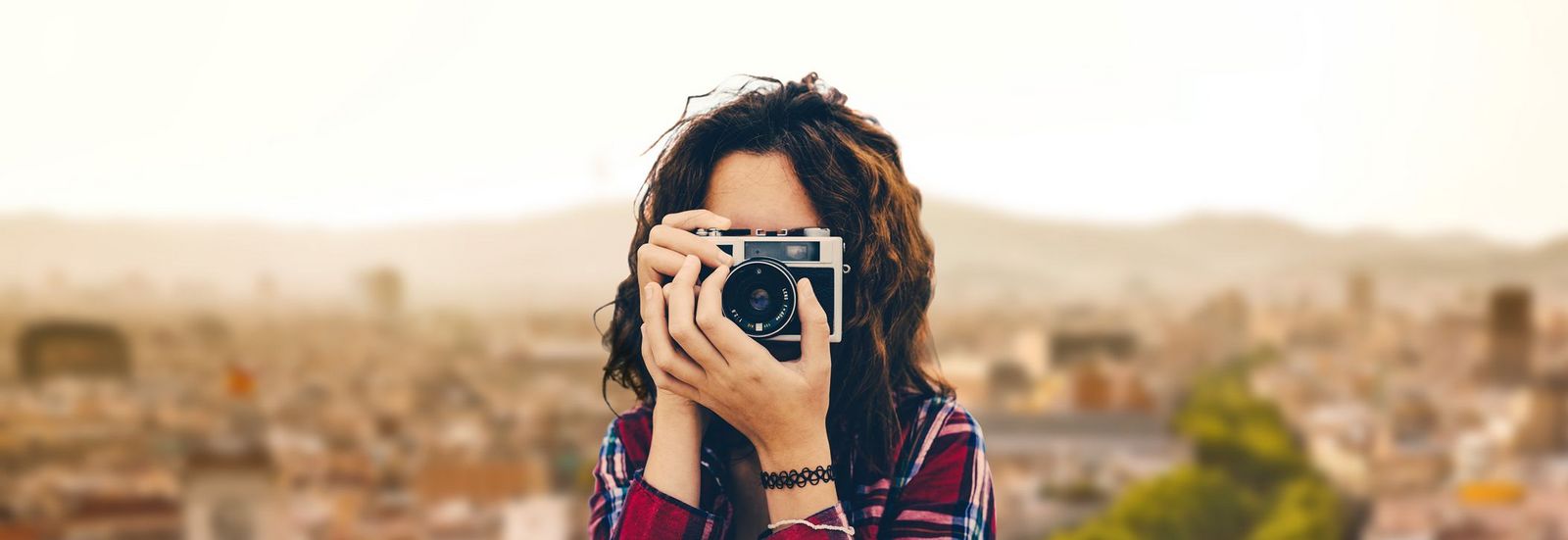Reiseblog Frau mit Kamera vor Metropole