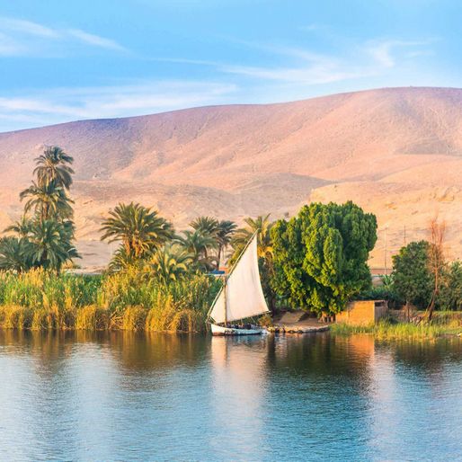 Aussicht auf ein Segelschiff mit weissem Segel auf dem Nil in Aegypten