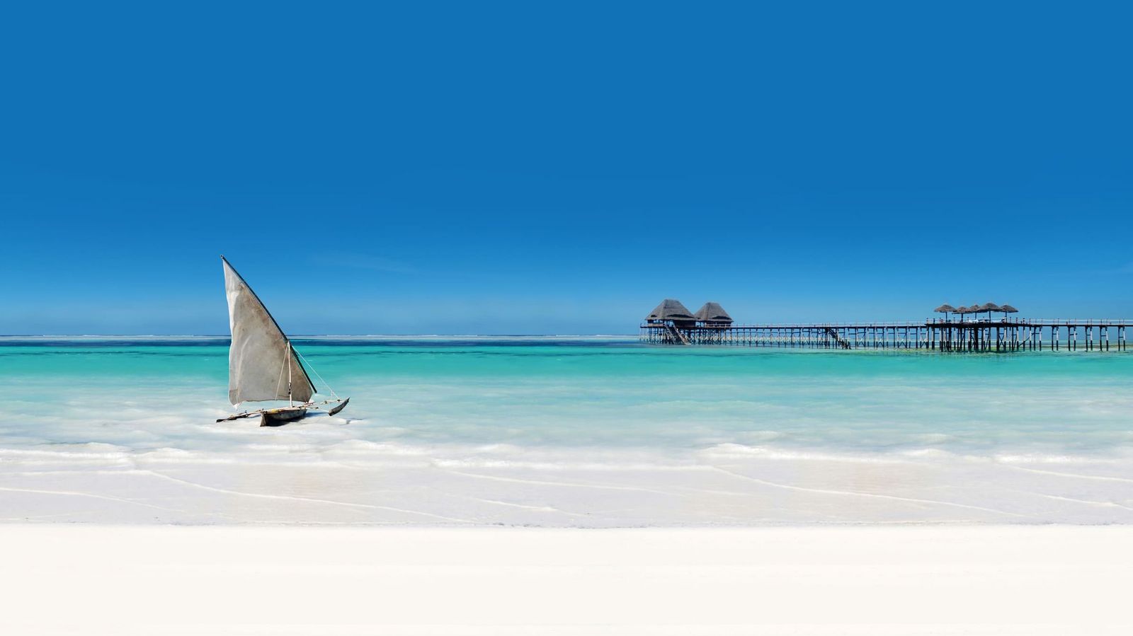 Strand mit einem Steg und einem Fischerboot in Sansibar