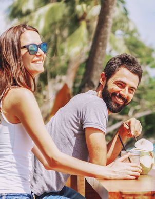 Ein Mädchen mit pinker Sonnenbrille geniesst in den Ferien einen Drink im Pool