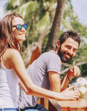 Ein Mädchen mit pinker Sonnenbrille geniesst in den Ferien einen Drink im Pool