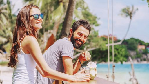 Ein Mädchen mit pinker Sonnenbrille geniesst in den Ferien einen Drink im Pool