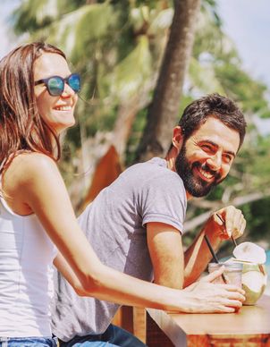 Ein Mädchen mit pinker Sonnenbrille geniesst in den Ferien einen Drink im Pool
