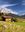 Panoramaausblick bei prächtigem Wetter auf eine Hütte, Felder und den Bergen in Österreich